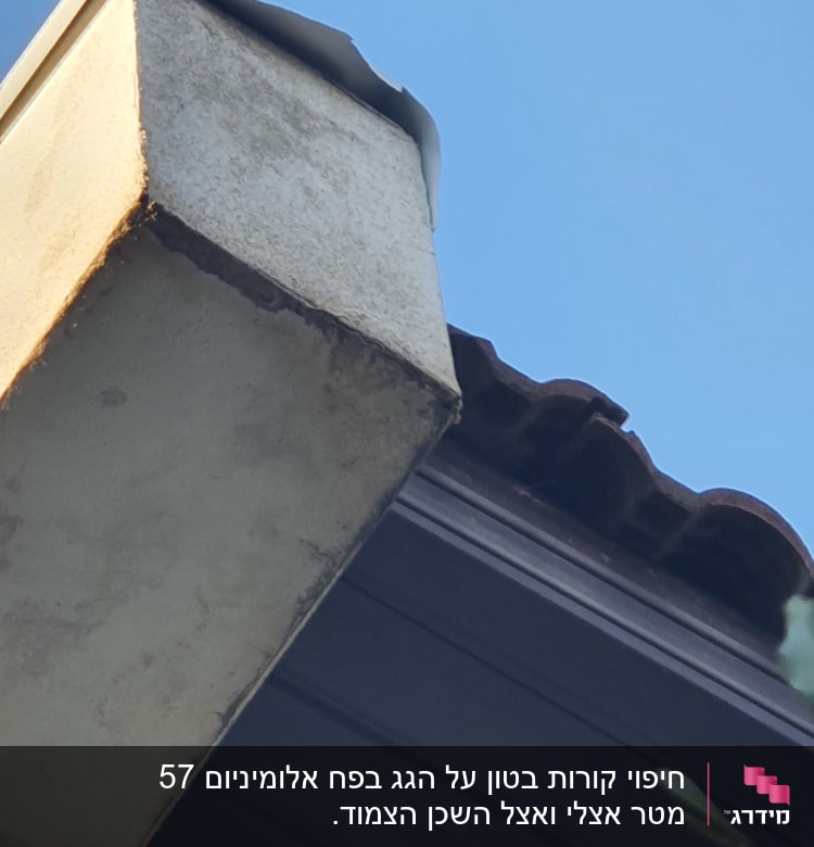 גג רעפים עם קצה בטון חשוף ושמיים כחולים